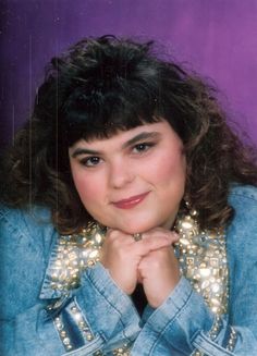 an old photo of a woman with her hands on her chin and wearing a denim jacket