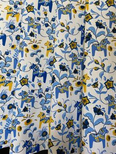 the curtain is decorated with blue and yellow flowers on white fabric, which has an elephant design