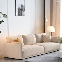 a living room filled with furniture and a white table next to a large glass window