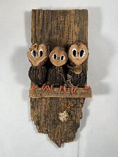 three owls sitting on top of a piece of wood