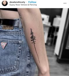 a small pine tree tattoo on the left arm