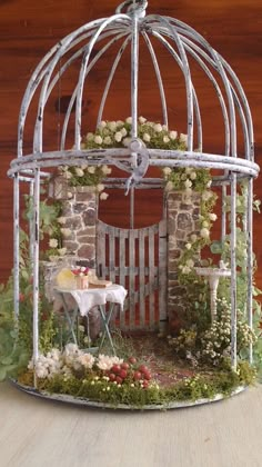 a small white birdcage sitting on top of a table