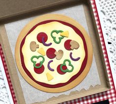 a pizza with toppings is in a cardboard box on a tableclothed surface