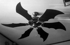 a black and white photo of a ceiling fan with bats on it's blades