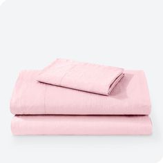 two sheets are folded on top of each other, one is pink and the other is white