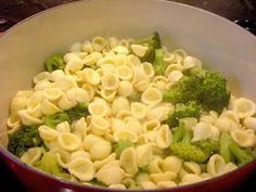 a pot filled with pasta and broccoli on top of a stove