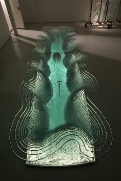 an art piece is shown in the middle of a floor with water flowing down it