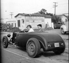 an old black and white photo of two people in a car