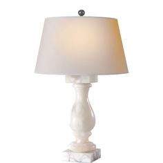 a white table lamp with a beige shade on it's base and a marble base