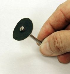 a person holding a small metal object in their right hand and pointing it at the other side