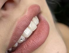 a close up shot of a woman's mouth with white teeth