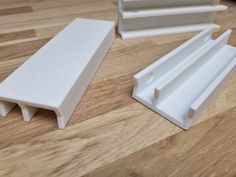 two white plastic pieces sitting on top of a wooden table