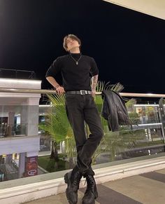 a man standing on top of a balcony next to a building