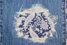 an old pair of jeans has been torn down and is decorated with paisley designs on it