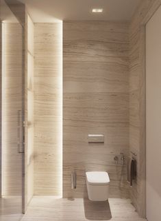 a white toilet sitting in a bathroom next to a walk - in shower and wall mounted soap dispenser