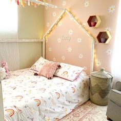 a child's bedroom decorated in pastel colors with pink and yellow accents, including a large bed