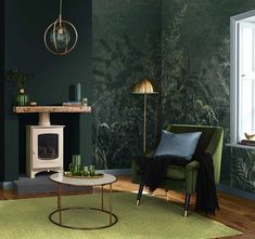 a living room with green wallpaper and a white fire place in the corner next to a chair