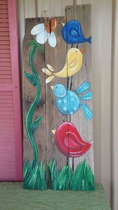 a wooden sign with birds painted on it