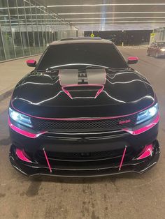 the front end of a black car with pink stripes