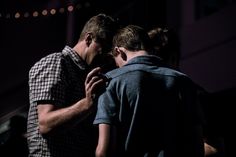 two men standing next to each other in the dark