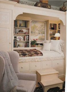 a bedroom with a bed, chair and bookshelf in it's corner