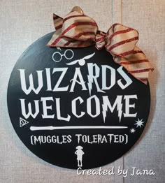 a sign that says wizard's welcome with a bow on the front of it