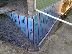 the side of a house that is under construction with cement and pipes in front of it