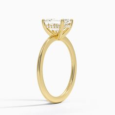 a yellow gold engagement ring with an oval cut diamond on the center and side stones