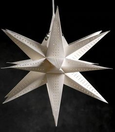 a white origami star hanging from a string