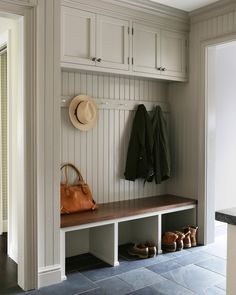 a coat rack with two coats hanging on it and some shoes in the foreground