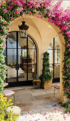 an image of the outside of a house with flowers growing on it and in front