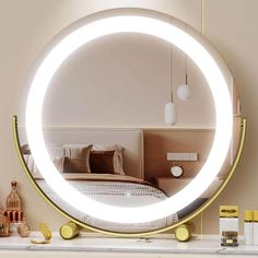 a round mirror sitting on top of a white counter next to a bed and nightstand