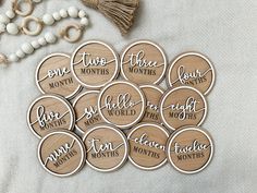 wooden badges with names on them sitting next to beads and tassels, one for each month