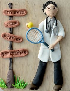 a cake made to look like a doctor holding a tennis racquet and ball