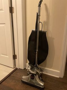 a vacuum is sitting on the floor in front of a door with a black bag