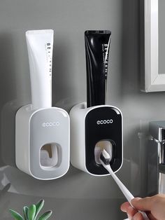 a person is holding a toothbrush in front of the bathroom sink and soap dispenser