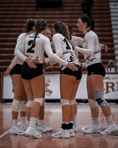 the volleyball team is huddling together on the court