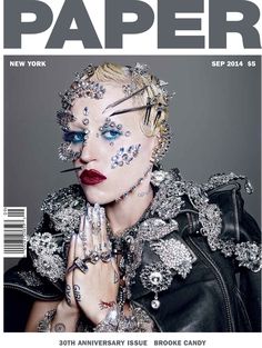 the cover of paper magazine with a woman wearing jewelry on her face and hands in front of her face