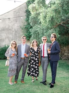 a group of people standing next to each other on top of a lush green field