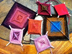 four square shaped lollipops sitting on top of a wooden table