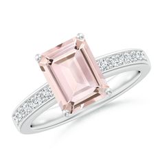 a pink tourmaline ring with diamonds on the sides and an emerald stone in the center