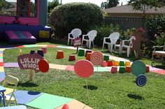 there are many colorful lawn decorations in the yard that is decorated with chairs and signs