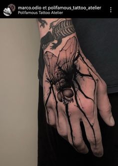 a person with a tattoo on their hand and the image of a spider crawling out of it