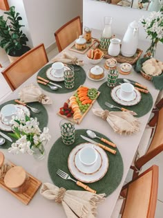 the table is set with dishes, plates and utensils