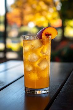 a glass filled with ice and fruit on top of a wooden table