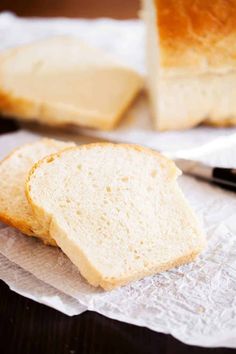 two slices of bread sitting on top of a piece of paper next to a knife