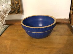 a blue bowl sitting on top of a wooden table