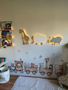 a child's room decorated in white with animals and train decals on the wall