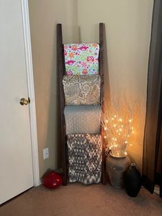 a stack of pillows sitting on top of a wooden chair next to a door with string lights