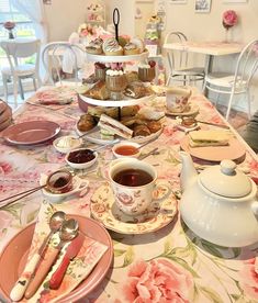 a table topped with lots of plates and cups filled with different types of food on top of it